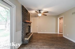 Kansas City house for rent - a living room with a fireplace and a ceiling fan