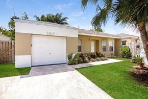 Cutler Bay house for rent - a yellow house with a white garage door and a lawn