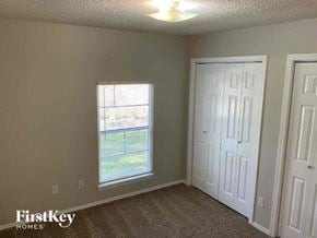 Conroe house for rent - an empty bedroom with a window and a door