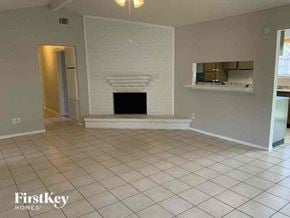 Conroe house for rent - a living room with a fireplace and a tiled floor
