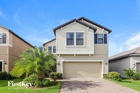 Ruskin house for rent - a house with a garage door and a palm tree in front of it