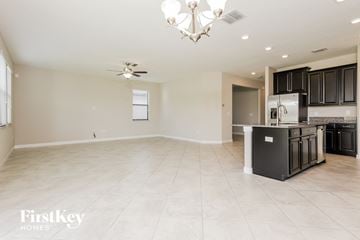 Ruskin house for rent - a kitchen and living room with black cabinets and tile flooring