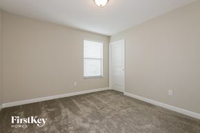 Ruskin house for rent - a bedroom with a carpeted floor and a white door