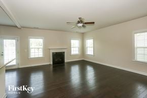Davidson house for rent - A spacious room with a fireplace and a ceiling fan.