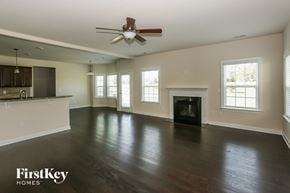 Davidson house for rent - A spacious living room with a fireplace and a ceiling fan.