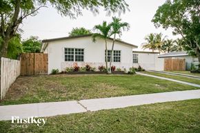 Cutler Bay house for rent - a white house with a lawn and palm trees