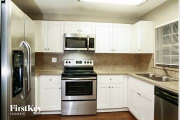Cutler Bay house for rent - a kitchen with stainless steel appliances and white cabinets