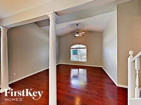 Indianapolis house for rent - an empty living room with wood floors and a ceiling fan