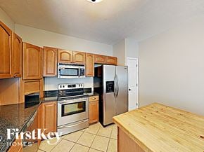 Indianapolis house for rent - a kitchen with stainless steel appliances and wooden cabinets