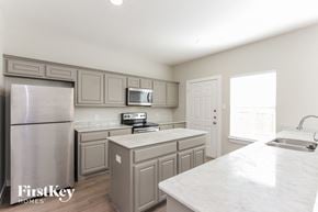 Dallas house for rent - a kitchen with white marble counter tops and stainless steel appliances