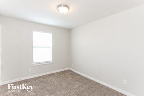 Dallas house for rent - a bedroom with a carpeted floor and a window