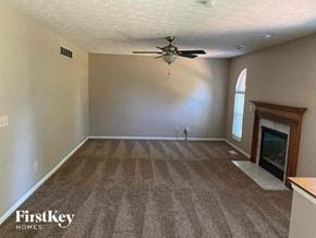 Loveland house for rent - A spacious room with a fireplace and a ceiling fan.