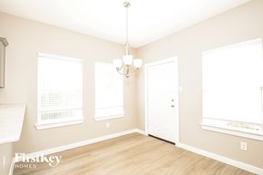 Dallas house for rent - A well-lit room with a chandelier and a white door.