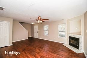 Charlotte house for rent - A spacious living room with wood flooring and a fireplace.