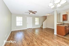 Cordova house for rent - A spacious room with wooden floors and a ceiling fan.