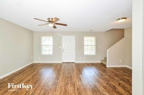 Cordova house for rent - A spacious room with wooden floors and a ceiling fan.