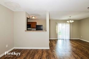 Cordova house for rent - A spacious room with wooden floors and a television mounted on the wall.