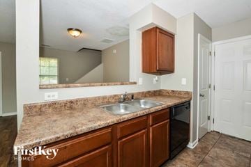 Cordova house for rent - A kitchen with brown cabinets and a granite countertop.