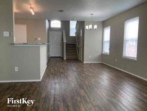 Dallas house for rent - an empty living room with wood floors and a kitchen