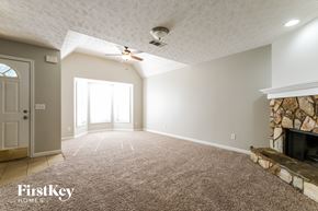 Canton house for rent - A spacious room with a fireplace and a carpet on the floor.