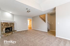 Canton house for rent - A spacious living room with a stone fireplace and a carpeted floor.