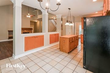 Charlotte house for rent - a large kitchen with a large island and a black refrigerator