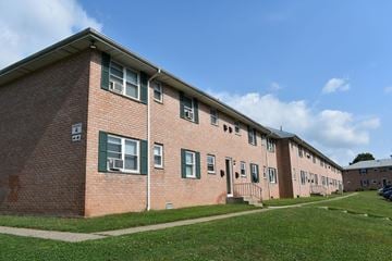 New City apartment for rent - a row of brick apartment buildings with green grass