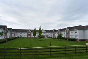 Holmdel apartment for rent - an apartment complex with a green lawn in front of it