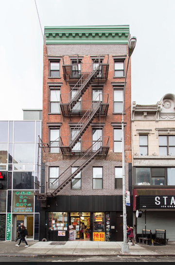 New York apartment for rent - the facade of a building with a fire escape