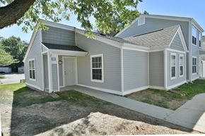 Peoria apartment for rent - a gray house with a sidewalk in front of it