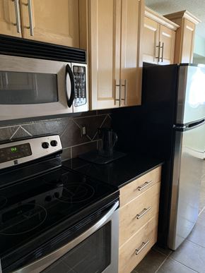 Edmonton house for rent - a kitchen with a stove and a microwave and a refrigerator
