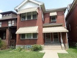 Pittsburgh apartment for rent - A red brick house with a white awning.