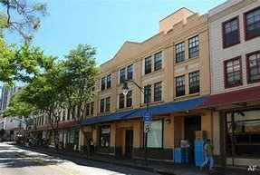 Honolulu apartment for rent - A street view of a row of buildings with a blue sky above.