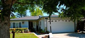 San Jose house for rent - A house with a white garage door and a tree in front.