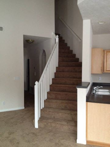 Omaha apartment for rent - a staircase in a house with a kitchen and a sink