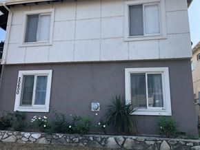 Winnetka apartment for rent - a house with two windows and a wall with flowers in front of it
