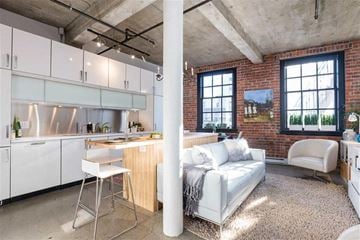 Vancouver apartment for rent - A kitchen with white cabinets and a white chair.