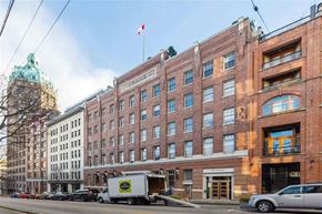 Vancouver apartment for rent - A street view of a city with a building that has a Canadian flag on top.
