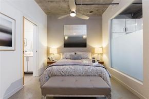 Vancouver apartment for rent - A bedroom with a bed, two lamps, and a ceiling fan.