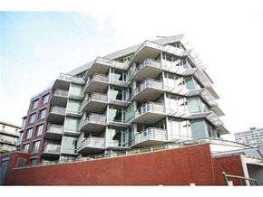 Vancouver apartment for rent - A large multi-story building with balconies on each floor.