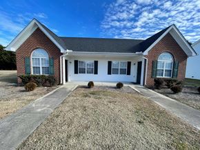 Rocky Mount apartment for rent - A brick house with a white door and green shutters.