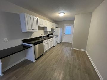 Rocky Mount apartment for rent - A kitchen with white cabinets and a black countertop.