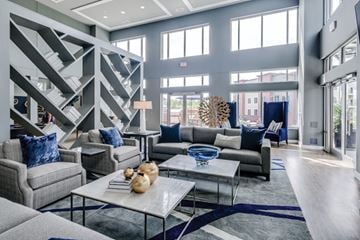 Frederick apartment for rent - a living room with couches and tables and a wall of windows