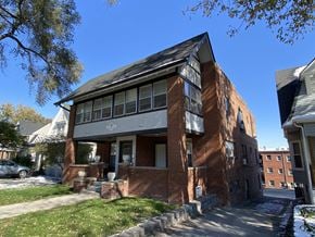Omaha apartment for rent - a red brick house with a black roof and a sidewalk