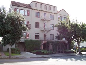 Alameda apartment for rent - A large building with a balcony and a tree in front of it.