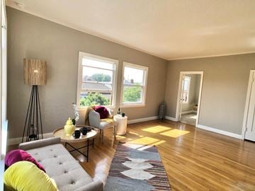 Alameda apartment for rent - A living room with a grey couch and a yellow pillow.