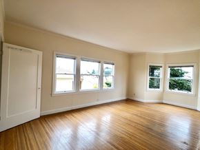 Alameda apartment for rent - A room with wooden floors and white walls has three windows.
