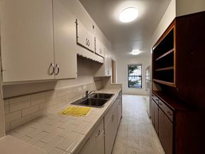 Alameda apartment for rent - A kitchen with white cabinets and a yellow dish towel on the counter.