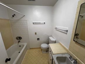 Alameda apartment for rent - A bathroom with a white tub, toilet, and sink.