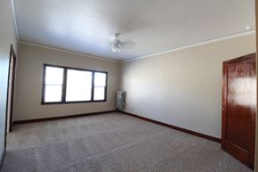 Alameda apartment for rent - A room with a carpeted floor, a ceiling fan, and a window with blinds.